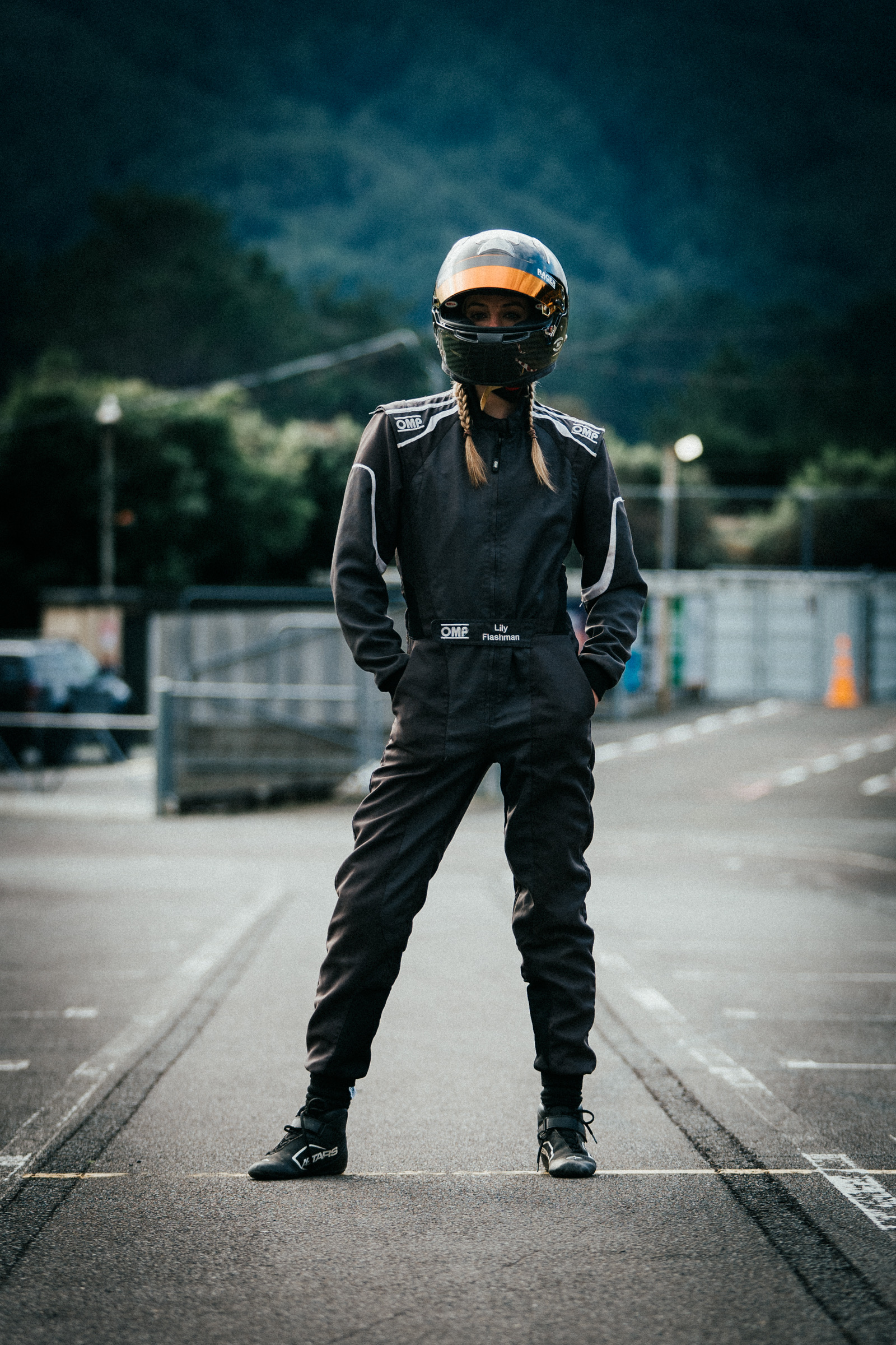 Lily helmet-on, planted on the grid — power stance