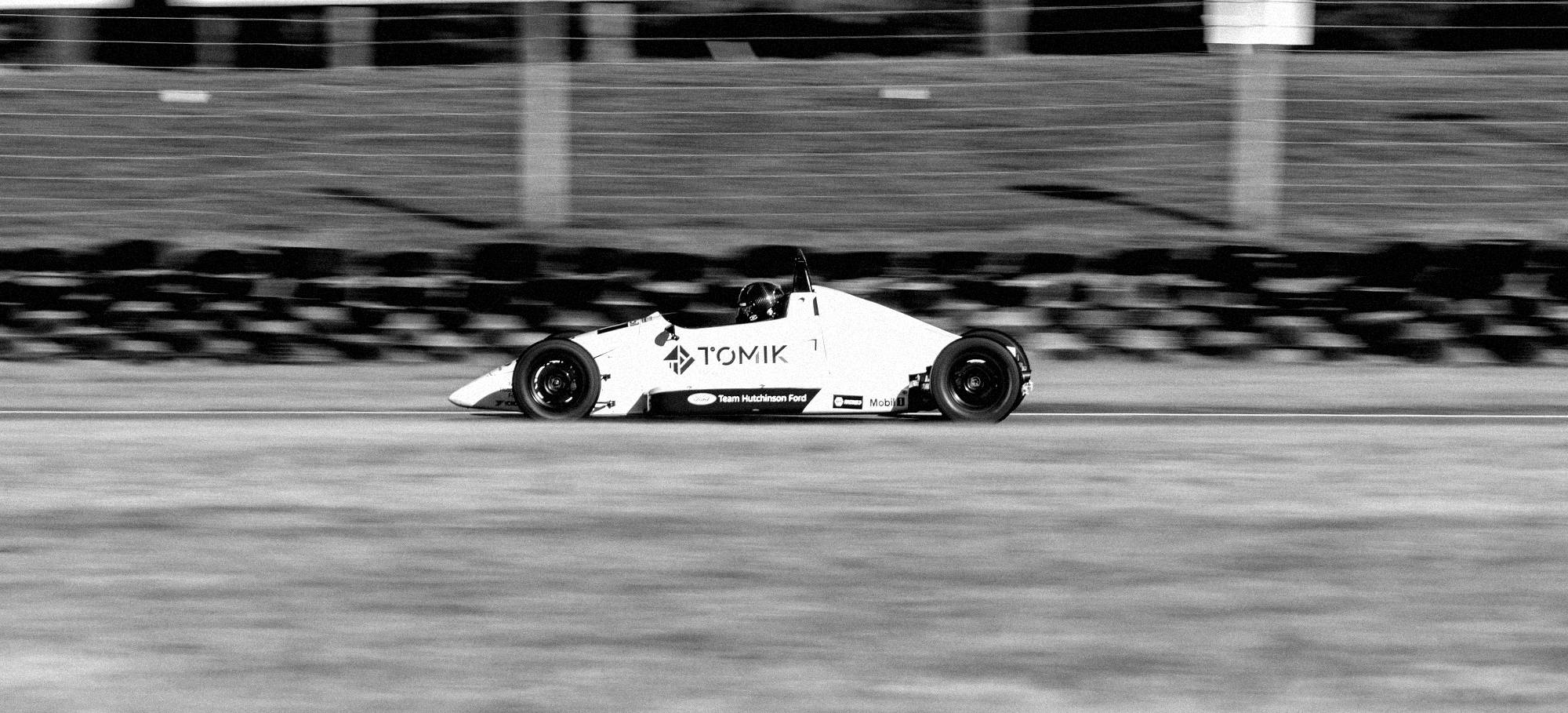 Lily Flashman's Formula Ford at speed — side profile, panning shot